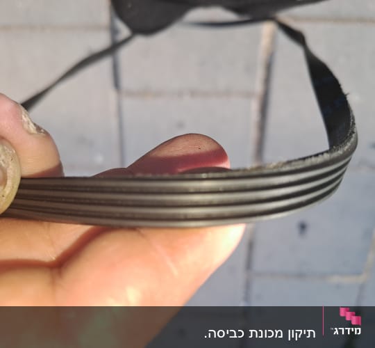 חוט חשמלי מוחזק ביד על רקע רצפה אפורה